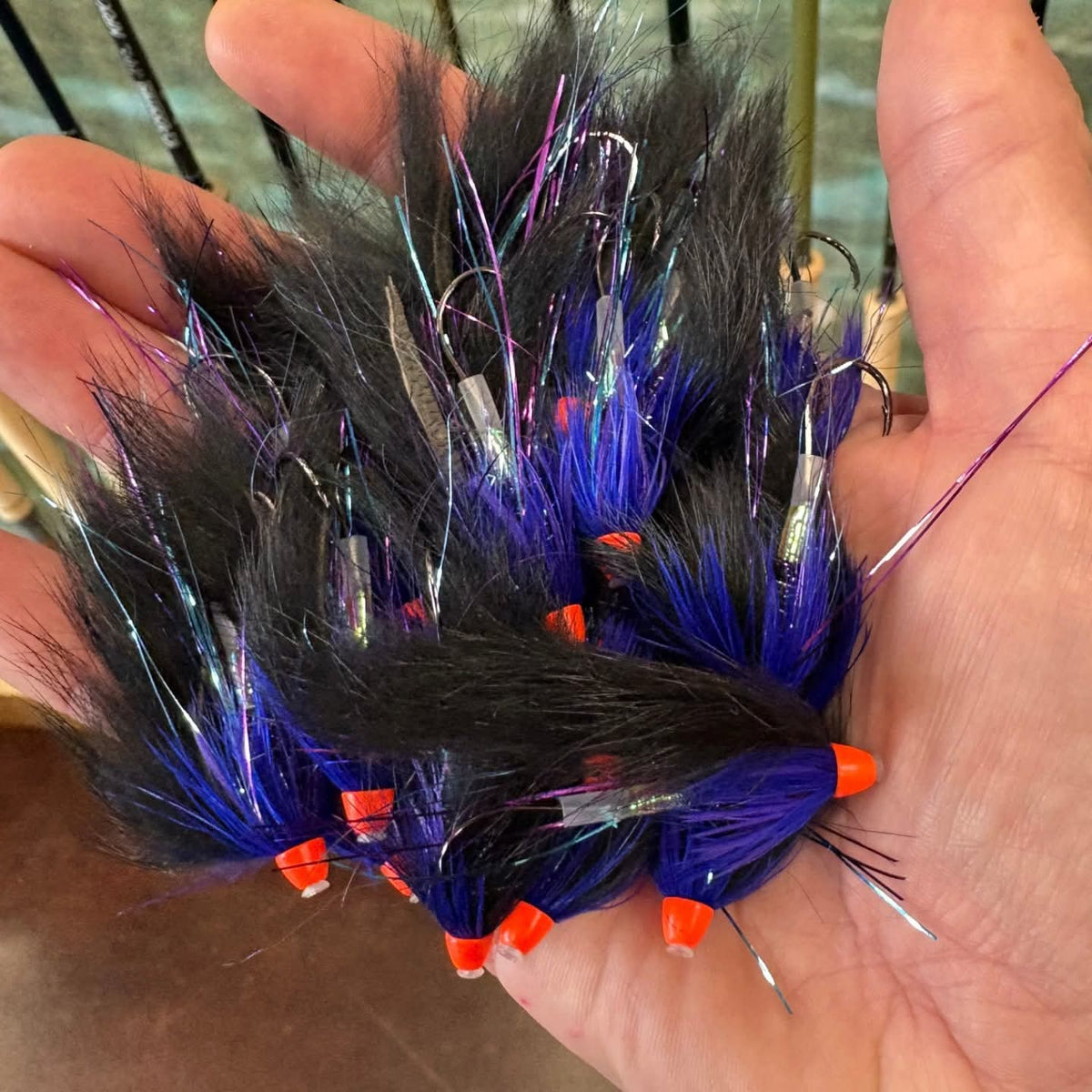 Hand holding a bundle of  Bunny Hare Leech -
with black, blue, and orange colors.